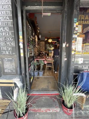 Facing glass paneled doors with black frame. Push on right to open.