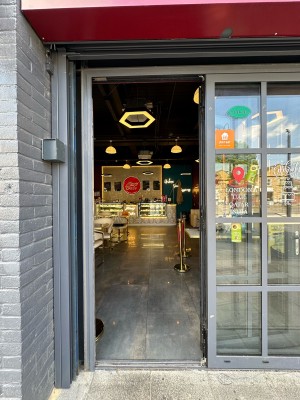 Glass door with grey frame. Push silver handle from left to open.