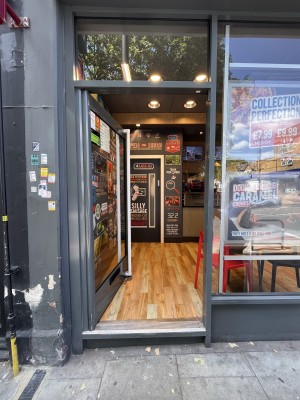 Glass door in grey frame. Push long white handle on right to open.