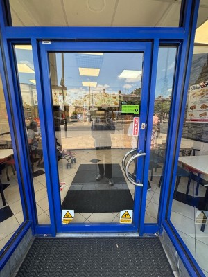 Glass door with blue frames. Pull from right handle to open.