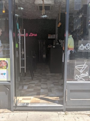 Glass door with metal frame and metal handle. Push from right to open.