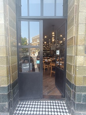 Glass door with black, wooden frame. Push from middle to open.