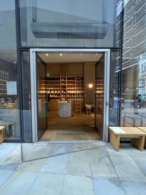 Facing entrance. Metal framed doors ahead. Push silver vertical handles at centre to open. Glass walls on either side.