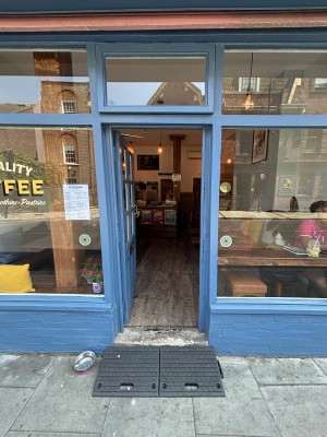 Blue door with glass panels. Push from right to open.