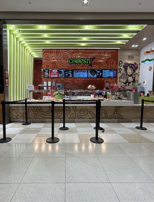 From seating area facing right. Restaurant barriers ahead to counter at back. Collect at back right.