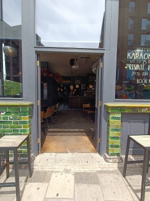 Glass doors with grey, wooden door ahead. Push from middle to open.