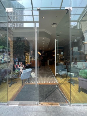 Facing glass doors. Push handle in center to open.