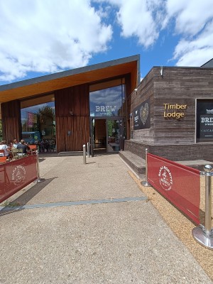 From street, facing venue. Restaurant barriers along both sides. Path ahead. Doorway at back.