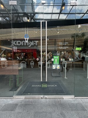 Glass doors with silver handles in centre. Push to open.