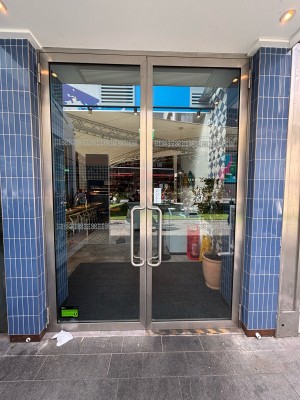 Glass doors with silver frames. Pull from centre handles to open.