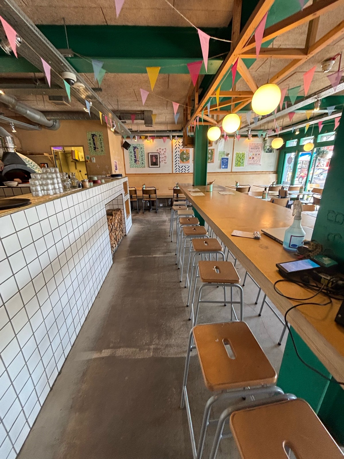 From high table facing right. Open kitchen on left. High table and stools on right.
