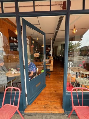 Glass door with blue frames. Push from right to open.