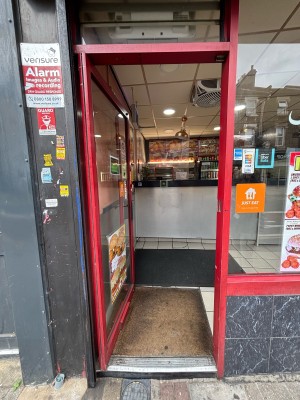 Glass door with red frames. Push from right to open.