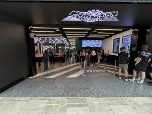 From mall facing venue. Opening ahead. Counter on back right.