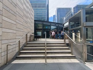 From street, facing venue. Stairs ahead. Silver handrail along both sides. Lift at back right.