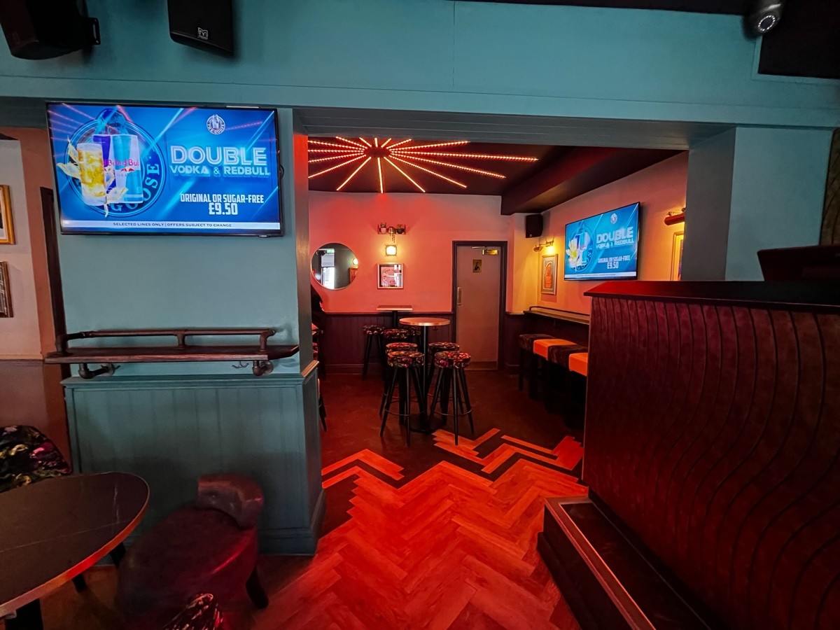 From music stage facing left. Table and stools to left. Column behind table.