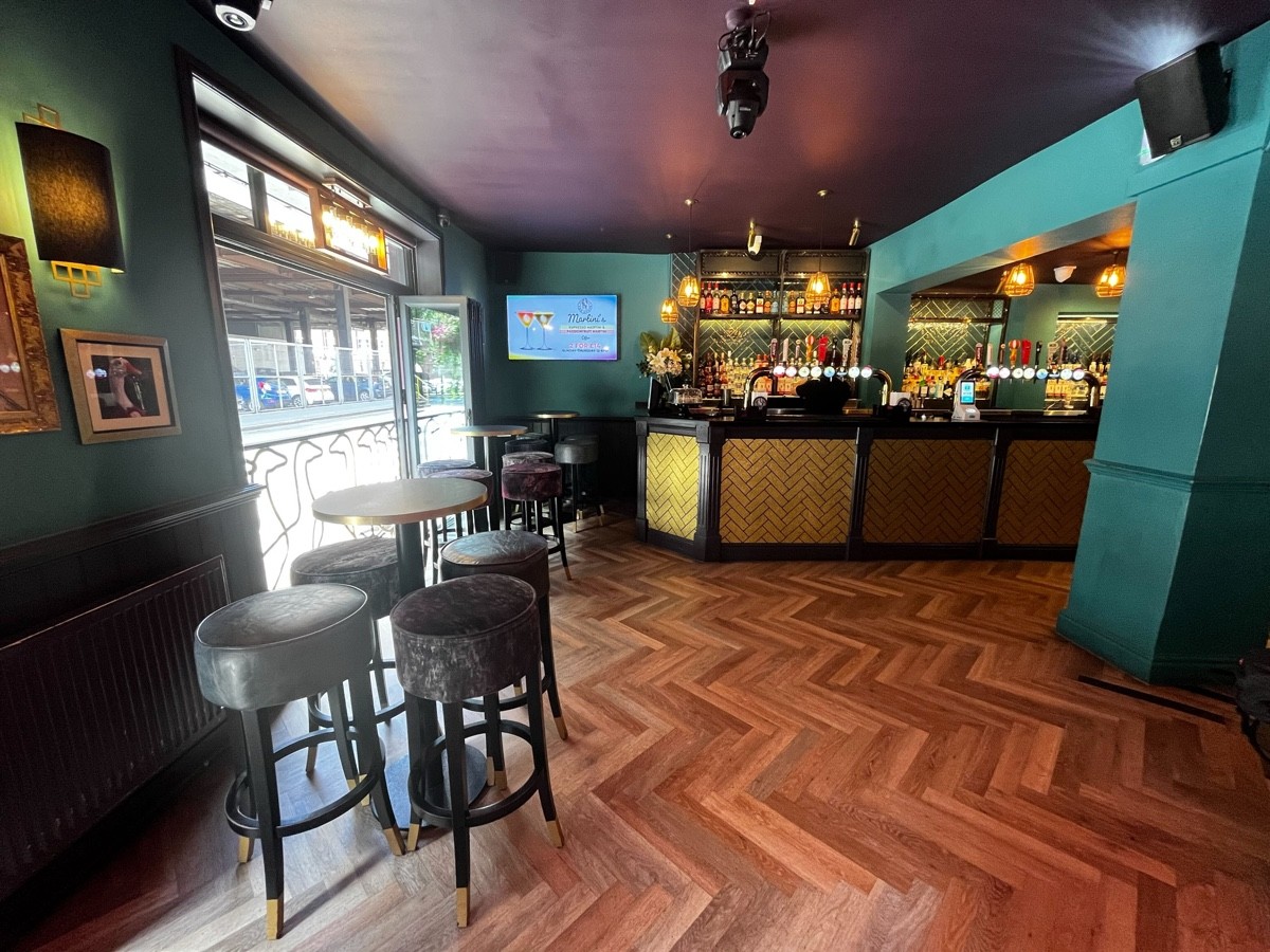 From entrance facing left. High tables and stool to left. Fence behind stools to left. Start of bar area to centre back.