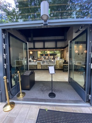 Glass doors with grey frames ahead. Push from metal handles in centre to open