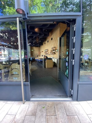 Glass door with grey frames ahead. Pull from handles in centre to open