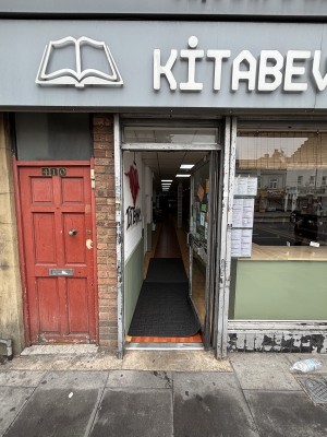 Glass door with metal frame. Push via handle on left to open.