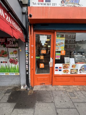Glass door with orange frame ahead. Push via handle on right to open.