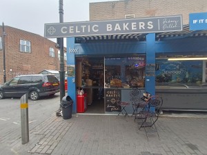 From street, facing venue. Path ahead to counter at back left. Seating on right.