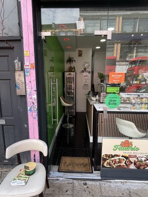 Glass door with metal handle on right. Push from right to open.
