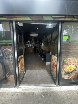 Glass doors with black frame ahead. Push black metal handles from centre to open.