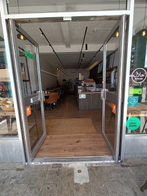 Glass doors with grey, metal frames. Push from middle to open.