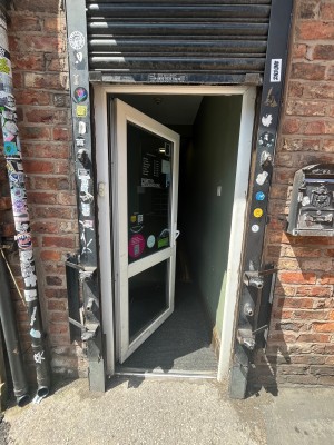 Glass single door with white handle. Push handle on right to open door.