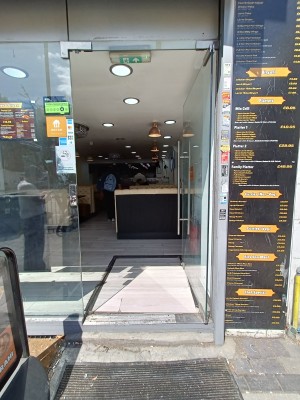 Glass door with silver, metal handle on left. Push to open.