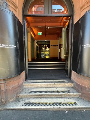 Three steps up to first set of black doors. Push golden handles in centre to open.
