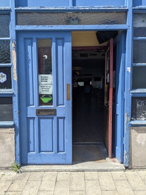 Blue doors with glass panels. Push from centre to open.