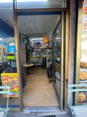 Glass door with brown, metal frame. Push from left to open.
