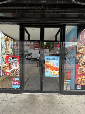 Glass doors with black frames ahead. Push via handles in center to open.