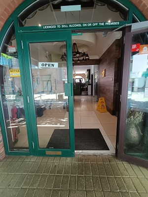 Glass door with green, metal frame. Pull handles from middle to open.
