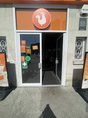 Glass doors with white frame ahead. Push grey metal handles from centre to open.