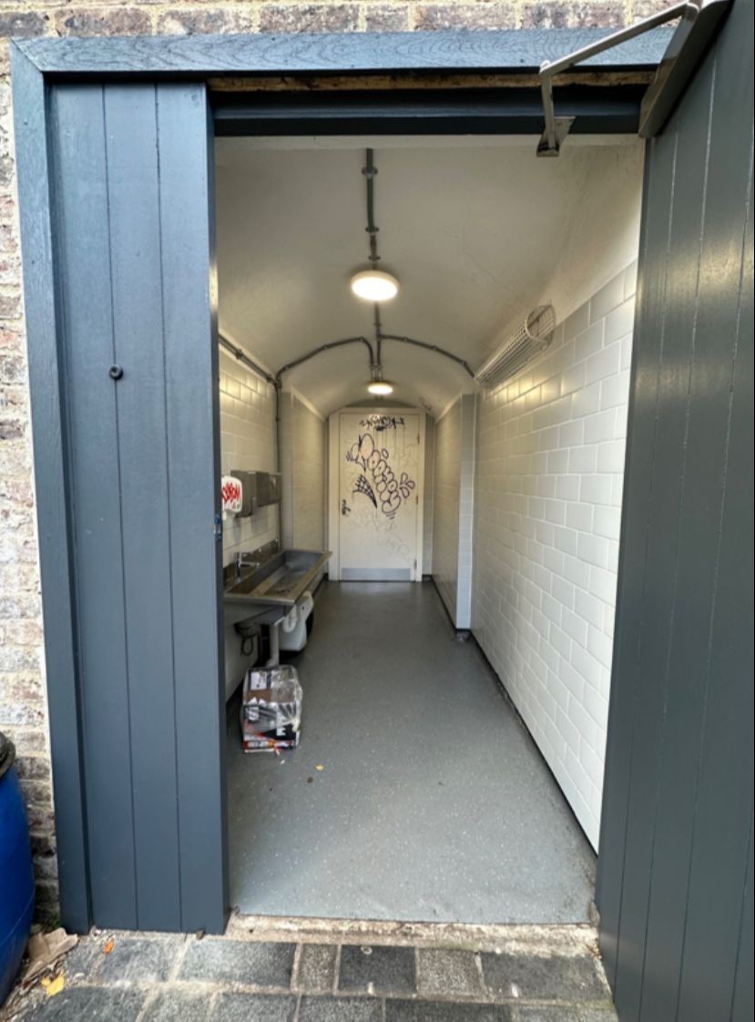 From preceding door facing straight. Sink on left. Path ahead to toilet door at back.