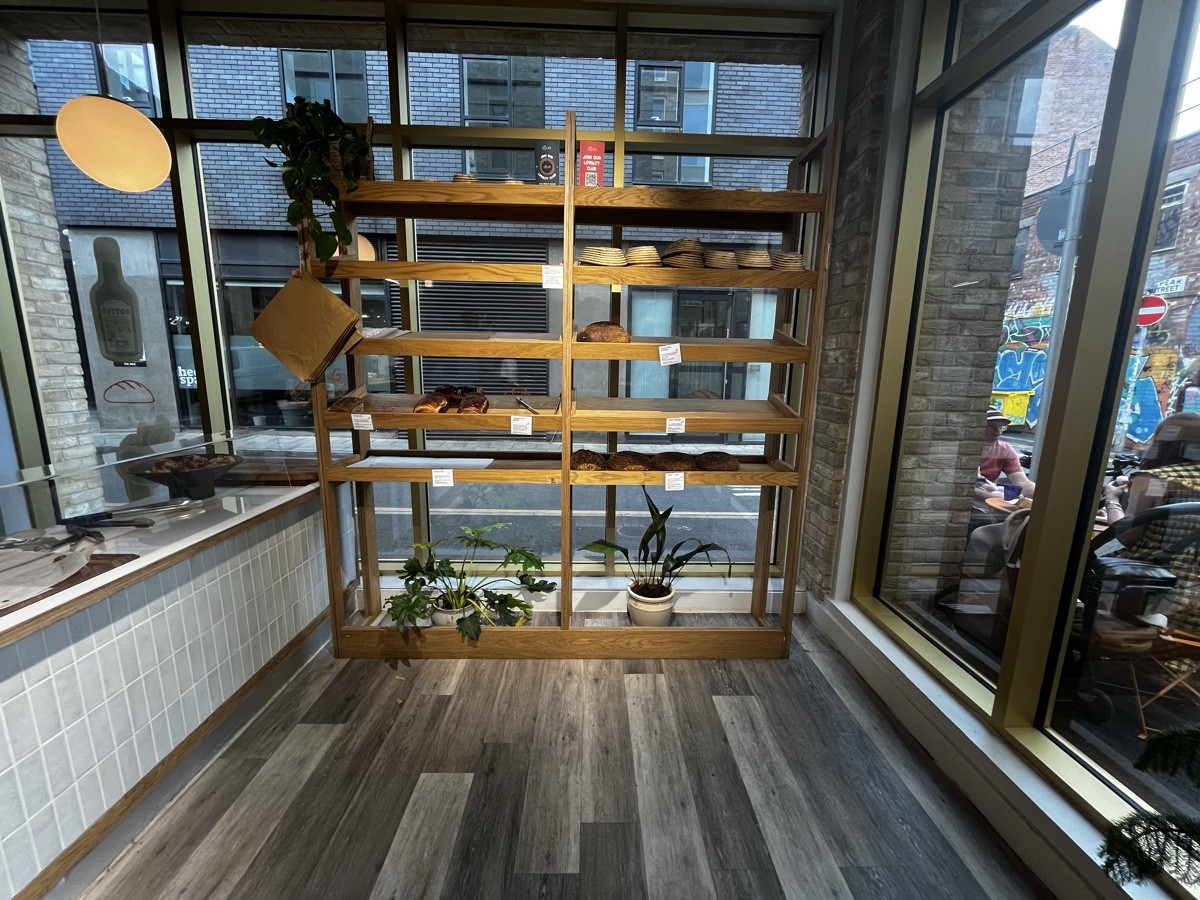 From door facing right. Product shelves ahead. Counter on left.