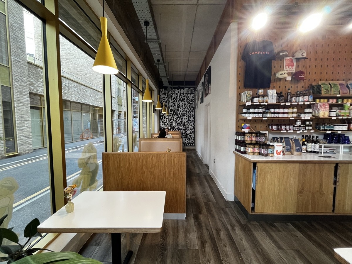 From pillar facing right. Booths along left. Product shelves on right.