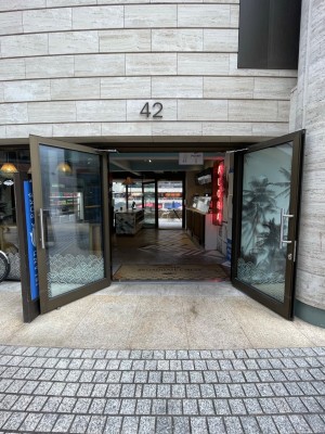 Facing entrance. Metal framed doors ahead. Pull silver metal vertical handles at centre to open.