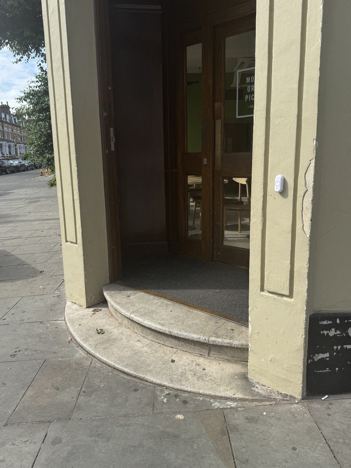 Steps to enter the cafe with a bell on the right wall.