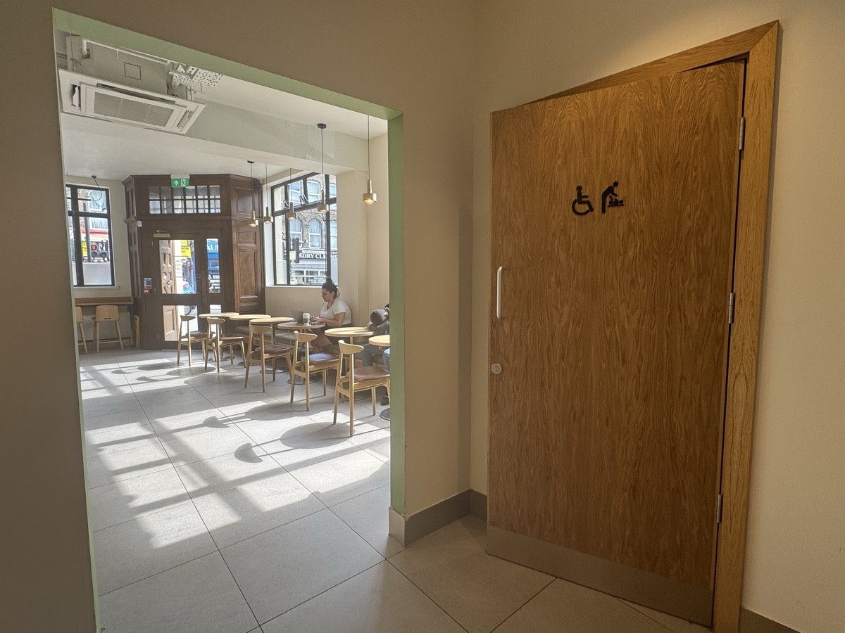 At the far end of the seating area is a large entrance to two toilets, one of which is accessible and equipped for baby care.