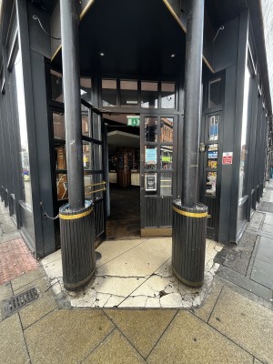 Preceding pillar on left and right. Entrance ahead between pillars.