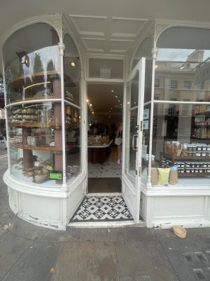 Glass door with white frame ahead. Gold metal handle from left to open.