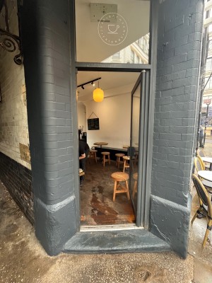 Glass door with silver frame and handle. Push handle on left of door to open.