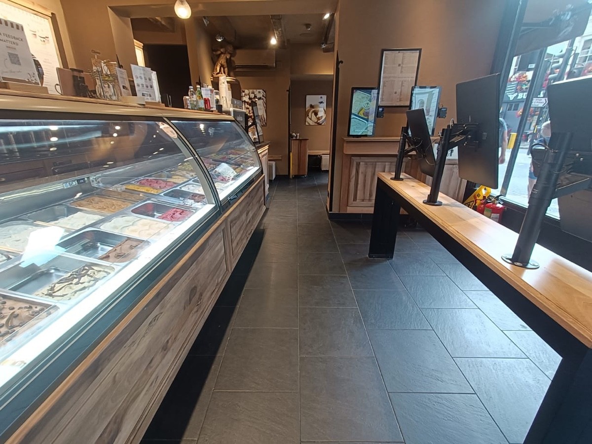 From start of counter facing right. Table along right. Product display along left followed by counter. Side area to back.