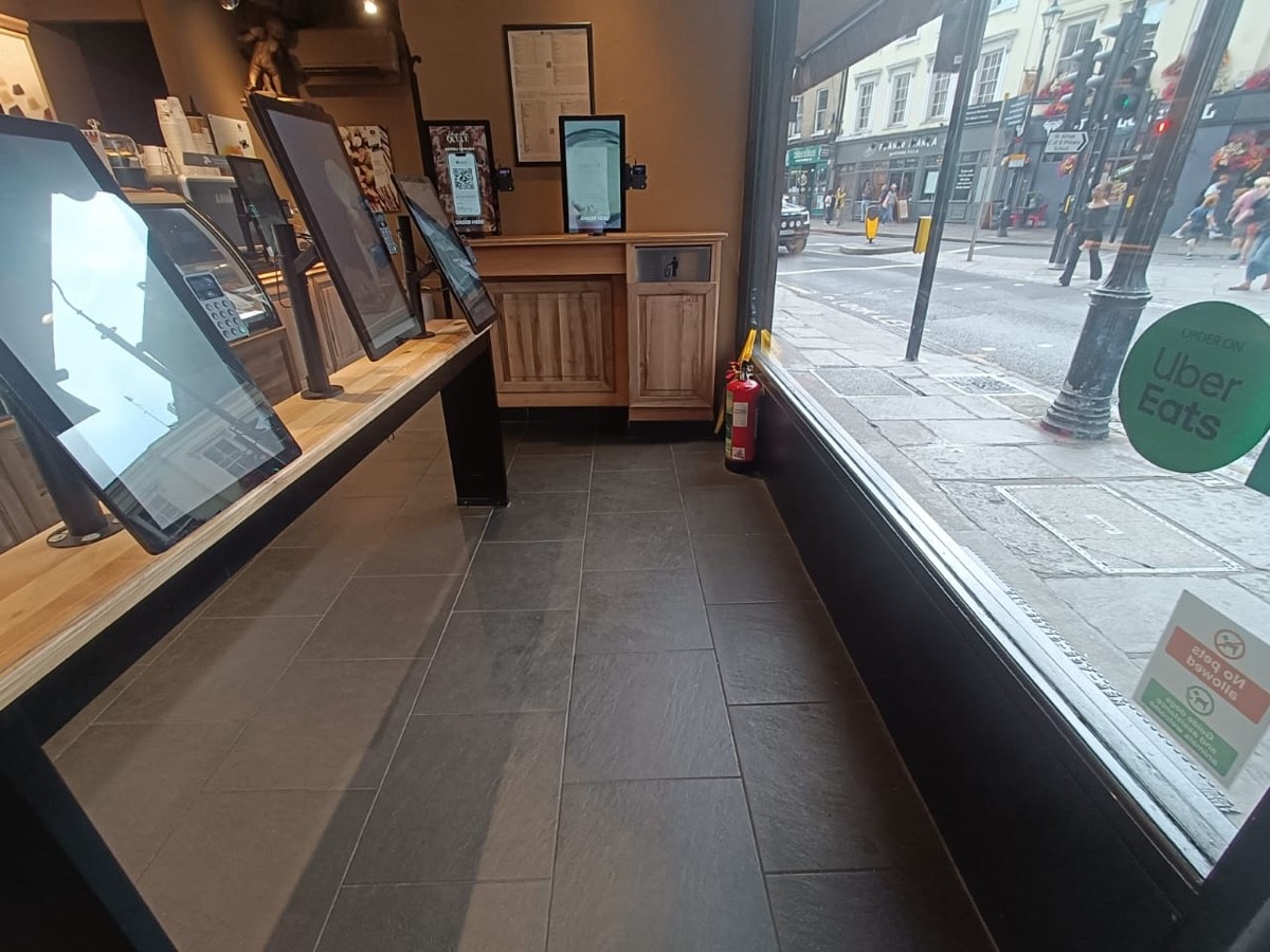From entrance facing right. Tables with ordering screens along left and on back.