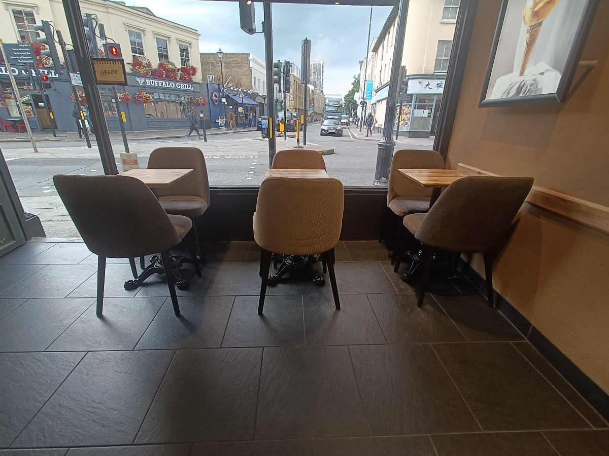 From opening, facing right. Tables and chairs along back. Second doorway at back left.