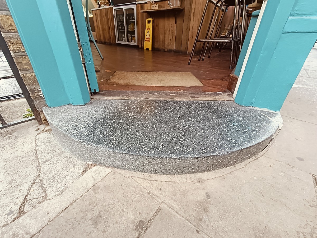 Step up before doorway. Small bump at threshold. Doormat after.